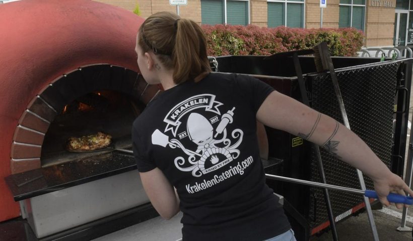 Lara Herrmann working her pizza oven.